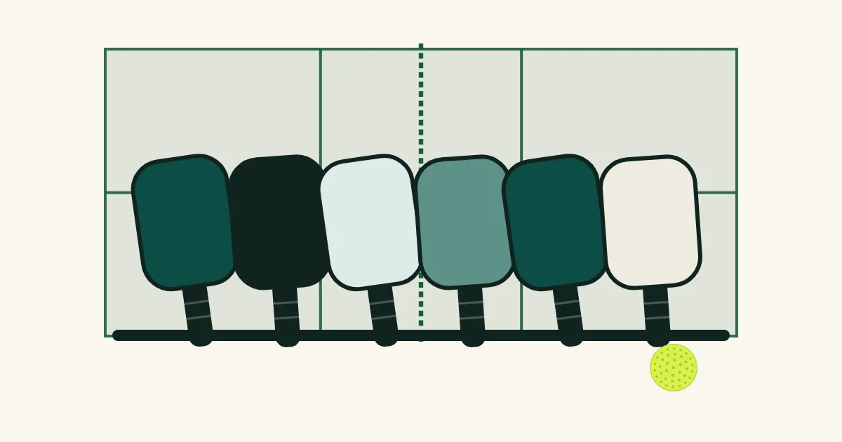 A row of paddles waiting in the open-play queue beside a court