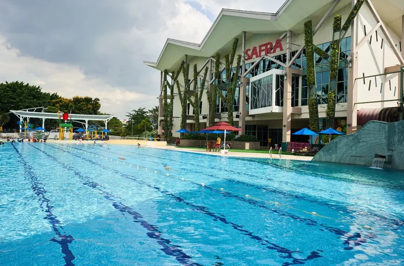 The SAFRA Jurong clubhouse, with its peaked roof and red SAFRA sign, seen across the club's outdoor swimming pool