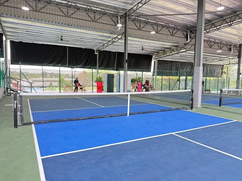 Blue covered pickleball courts under a steel roof at Syok Pickle, Bangi