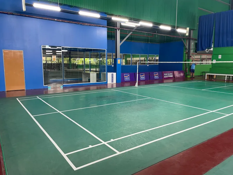 An indoor green court lined for pickleball, with a net across it, inside DStar Arena's hall with blue walls and bright overhead lights.